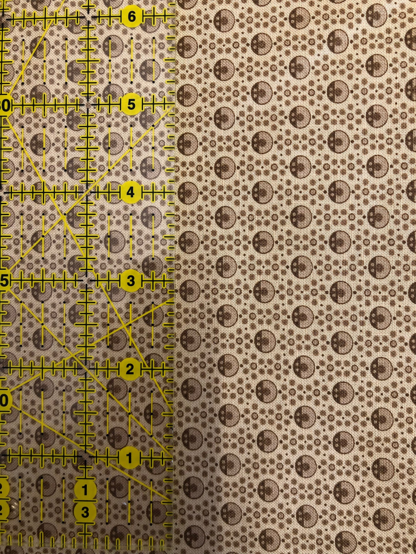 Jo Morton fabric, small brown rings and dots on tan, beside a ruler in inches
