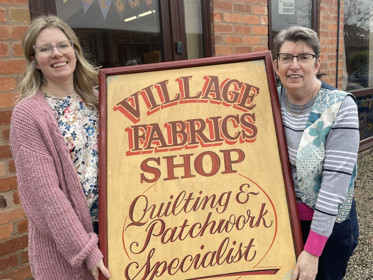 Helen and Yvonne outside Village Fabrics with the shop sign