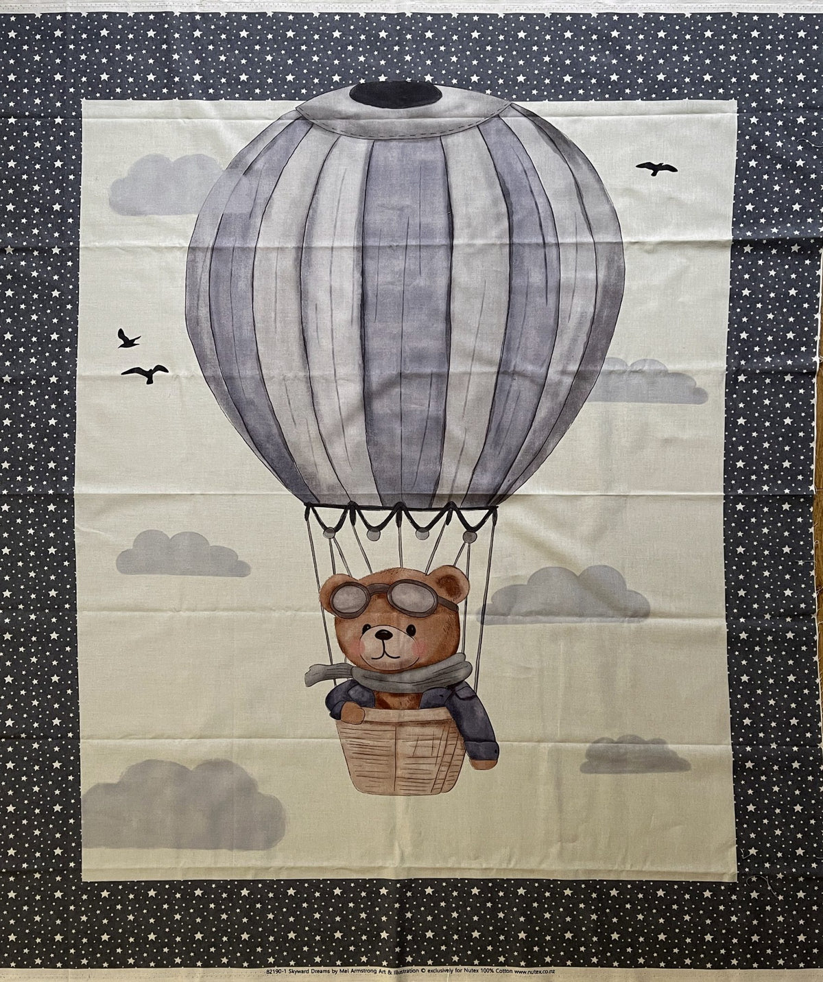 The Hot Air Balloon Bear Cot Panel: a bear in a grey striped balloon among clouds, with a starry charcoal border