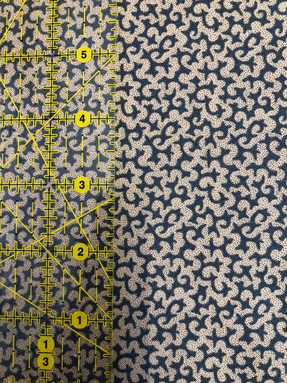 Jo Morton fabric, cream squiggles on navy blue, beside a ruler in inches