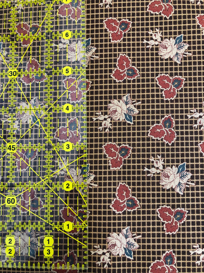 Jo Morton fabric, red leaves and cream roses on brown windowpane check, beside a ruler in inches