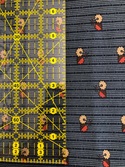 Jo Morton fabric, small cream and red flowers on navy fine stripe, beside a ruler in inches