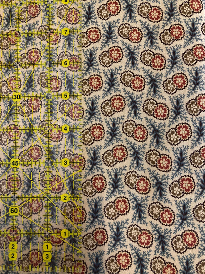 Jo Morton fabric, red, cream and blue paisley medallions on cream, beside a ruler in inches