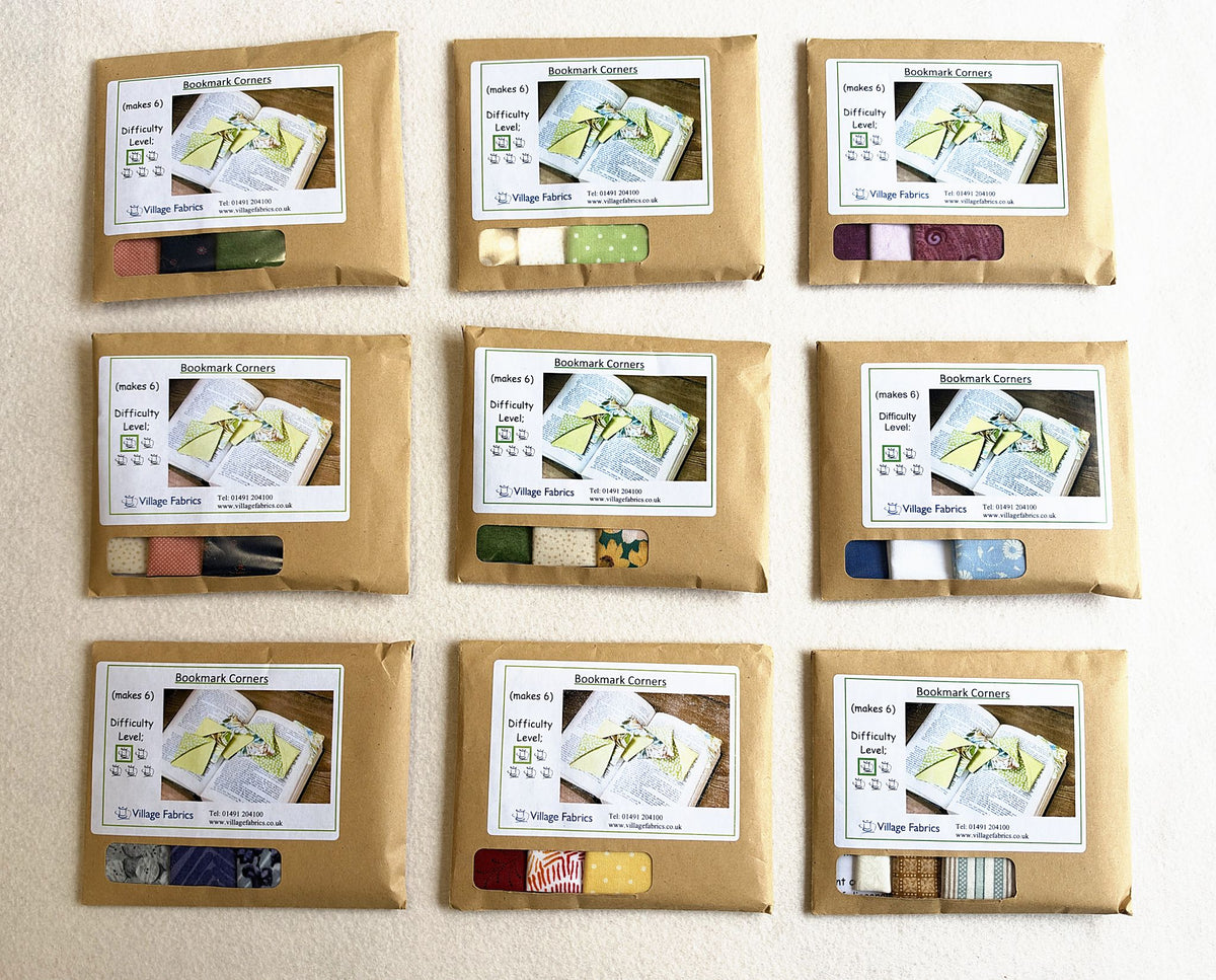 Bookmark Corners kits in nine colourways, each in a brown envelope with the fabrics showing through the window