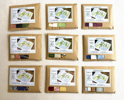 Bookmark Corners kits in nine colourways, each in a brown envelope with the fabrics showing through the window