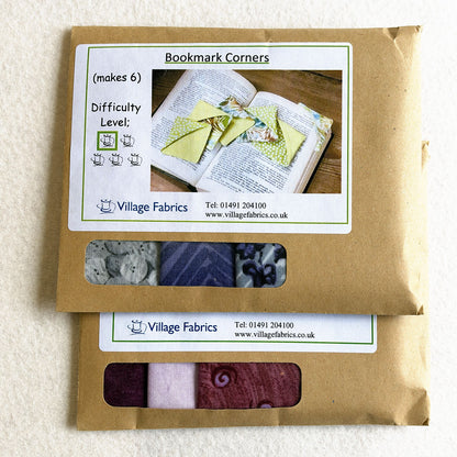 Two Bookmark Corners kits in Purple, showing how the fabrics vary: grey, violet and navy prints in one, plum, lilac and pink in the other