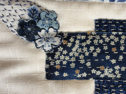 Close-up of the boro stitching: fussy-cut flowers and a navy patch held with rows of running stitch