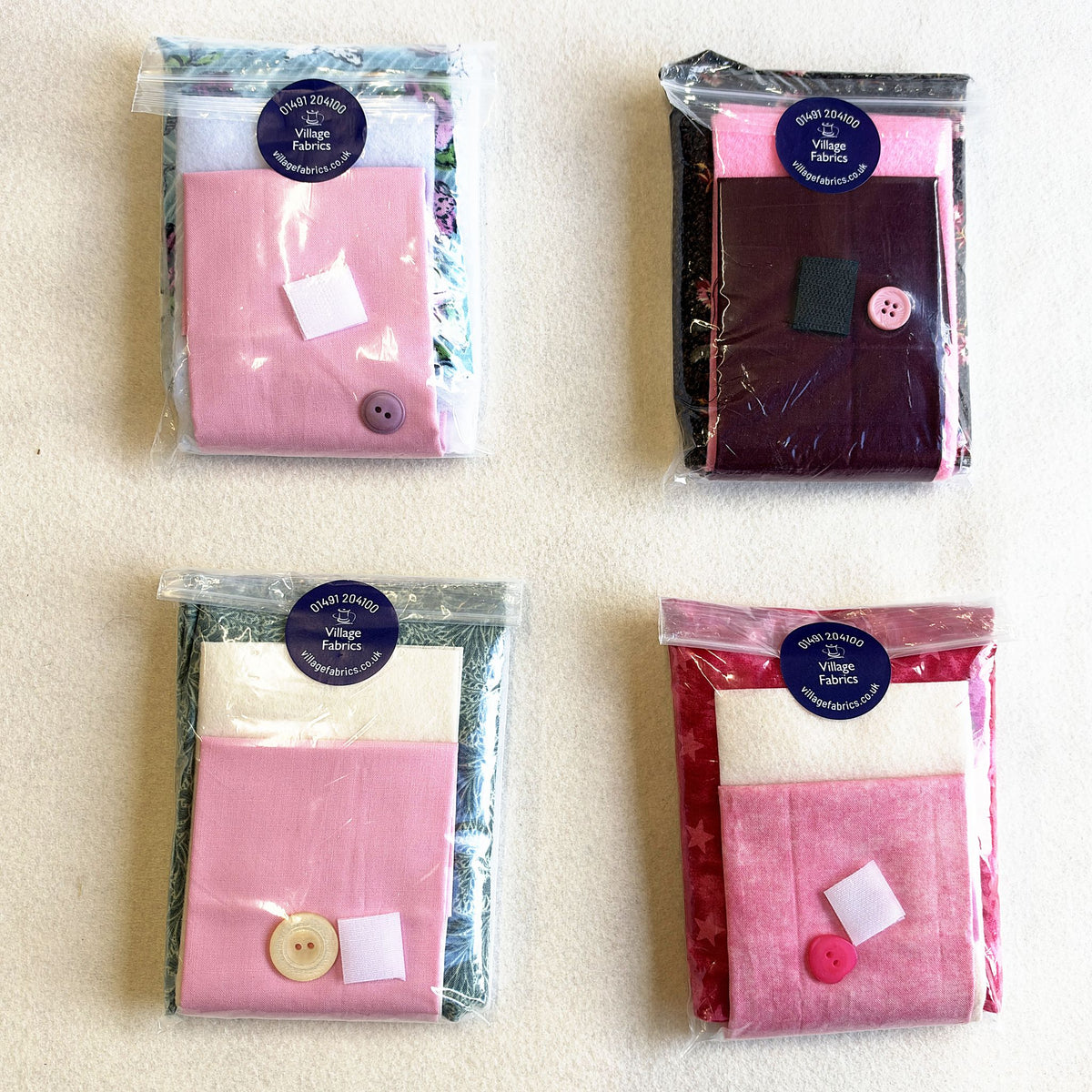Needle Nest kits in assorted fabrics, each with a button and a hook and loop fastening