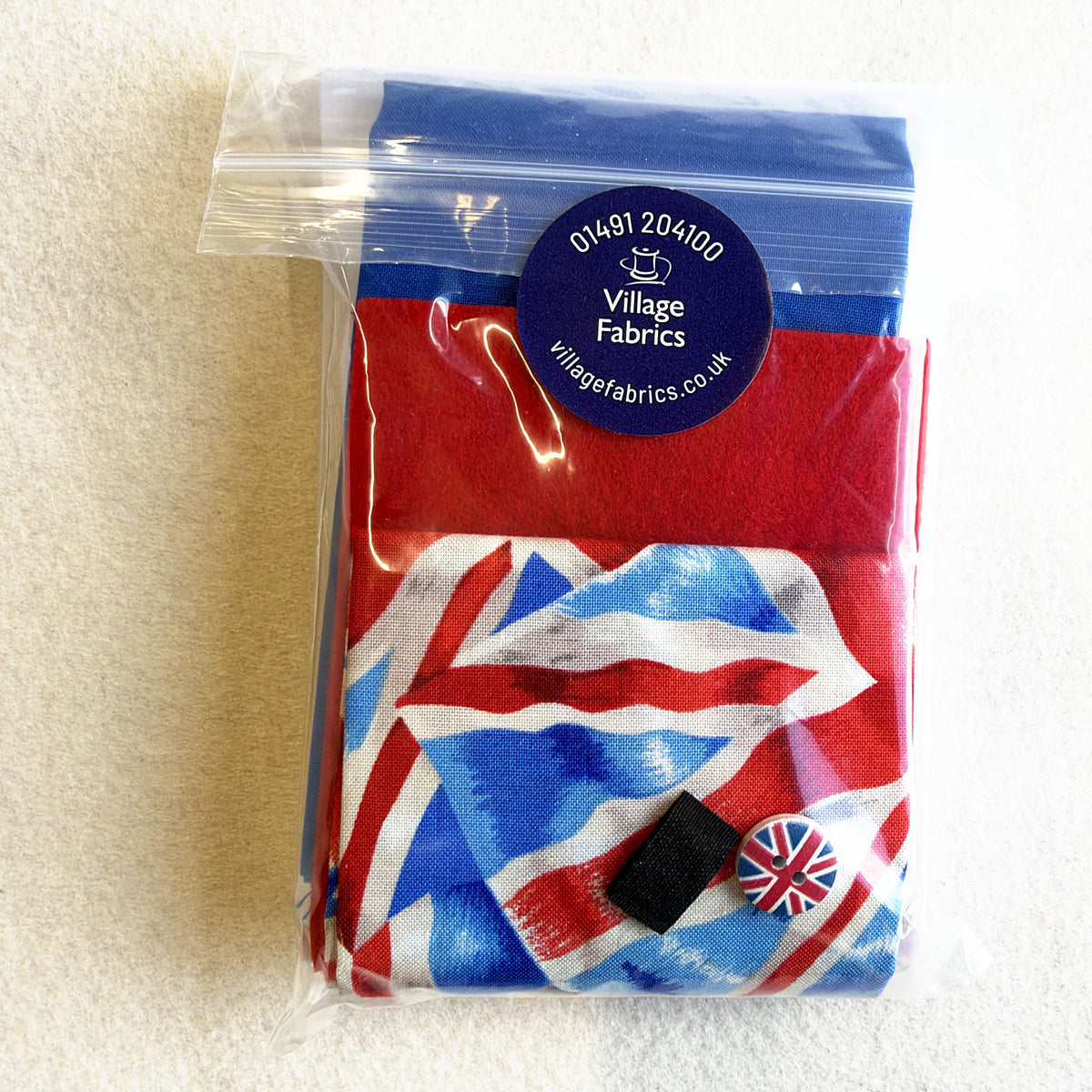 Union Flag Needle Nest kit in its bag: Union Flag fabric, red and blue fabrics, a button and a fastening