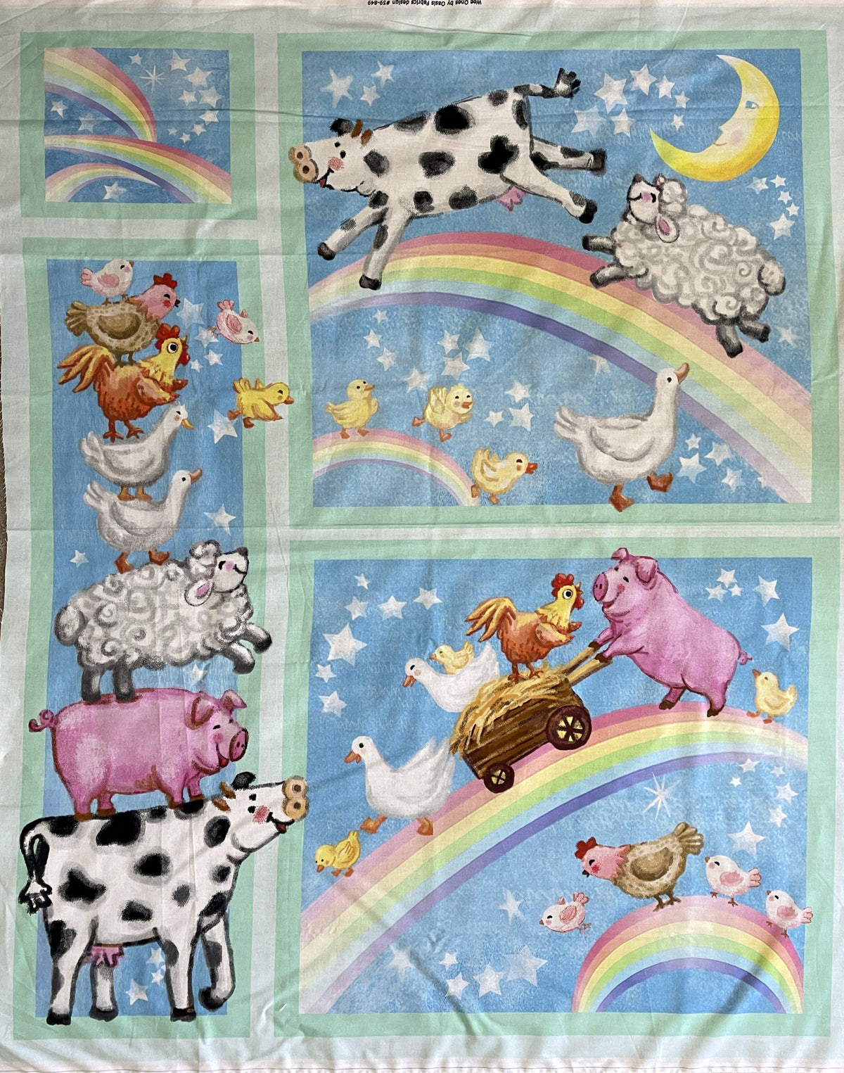 The Rainbow Farm Animals Cot Panel: a cow, sheep, pigs, hens and ducks with rainbows on sky blue